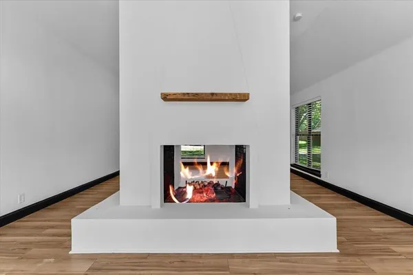 a view of a hallway with wooden floor and a fireplace