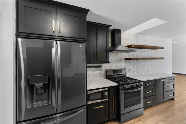 a kitchen with stainless steel appliances granite countertop a refrigerator and a stove