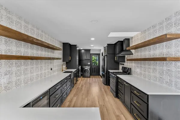 a kitchen with stainless steel appliances a sink stove and cabinets