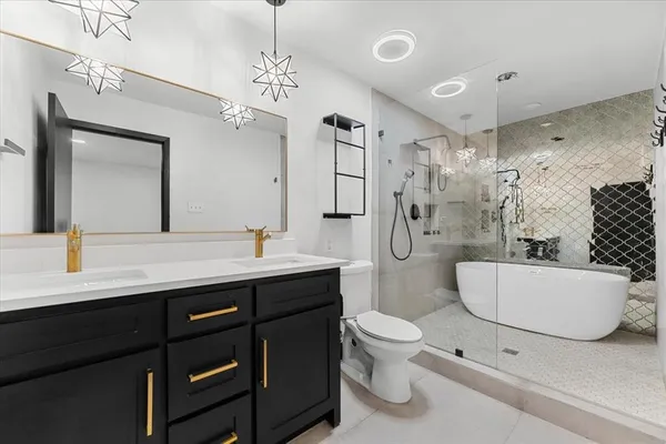 a bathroom with a double vanity sink toilet mirror and bathtub