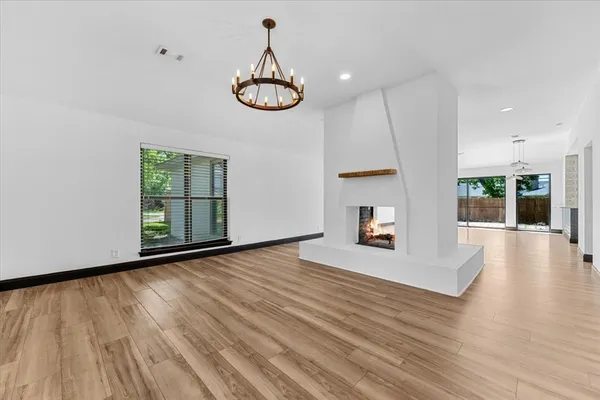 a view of empty room with wooden floor and window
