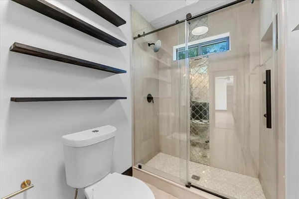 a bathroom with a shower a toilet and a sink