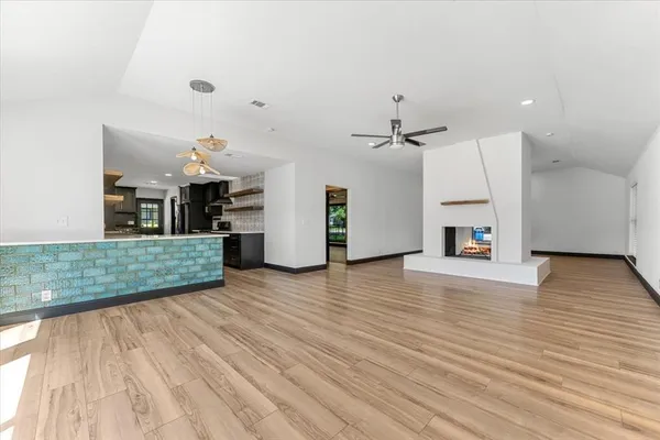a view of a room with wooden floor and a ceiling fan