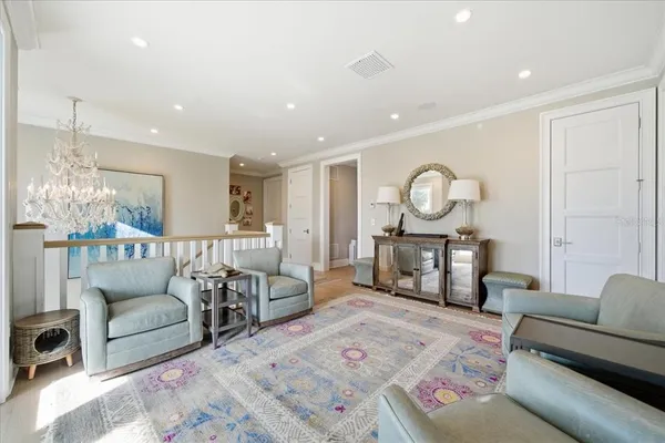 a large white kitchen with a sink a refrigerator and cabinets