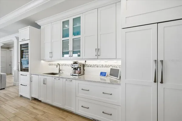 a kitchen with stainless steel appliances white cabinets and wooden floors
