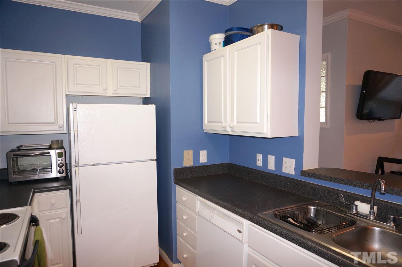 710 North Person Street, Unit 107 Raleigh, NC 27604 - Photo 10 of 21 a kitchen with a sink a refrigerator and cabinets
