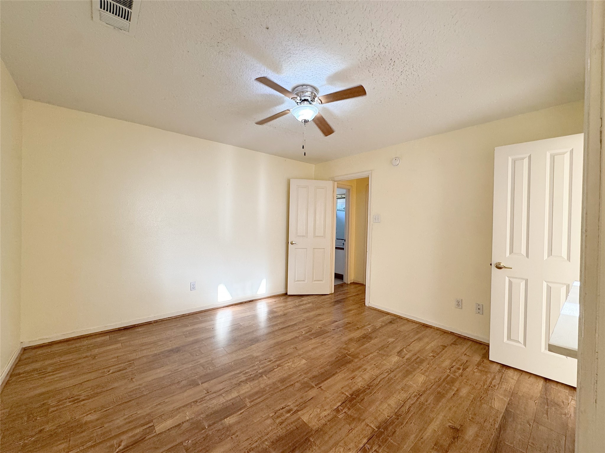 8631 Mapletwist Street Houston, TX 77083 - Photo 19 of 25 an empty room with wooden floor chandelier fan and windows