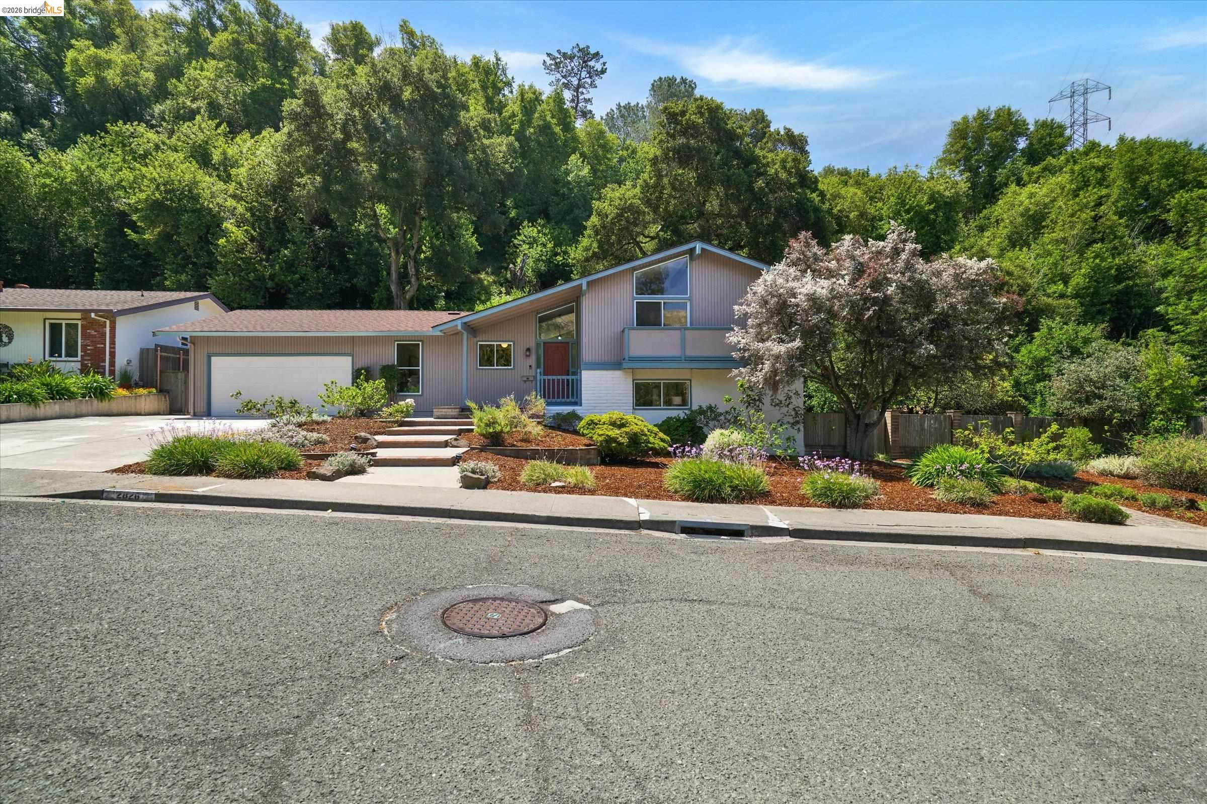 2826 Wright Avenue Pinole, CA 94564 - Photo 3 of 70 Contemporary single-story residence featuring a two-car garage, a red entry door, and multi-level landscaping