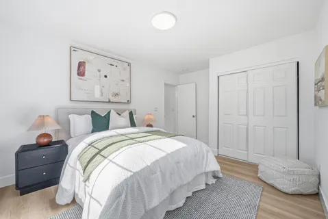 a bedroom with a bed and wooden floor