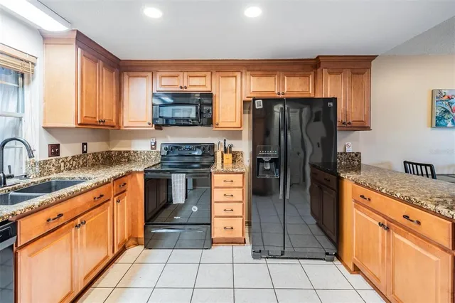 a kitchen with stainless steel appliances granite countertop a refrigerator and a stove top oven