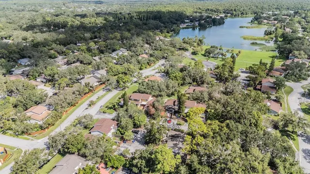 an aerial view of residential house with outdoor space and trees all around
