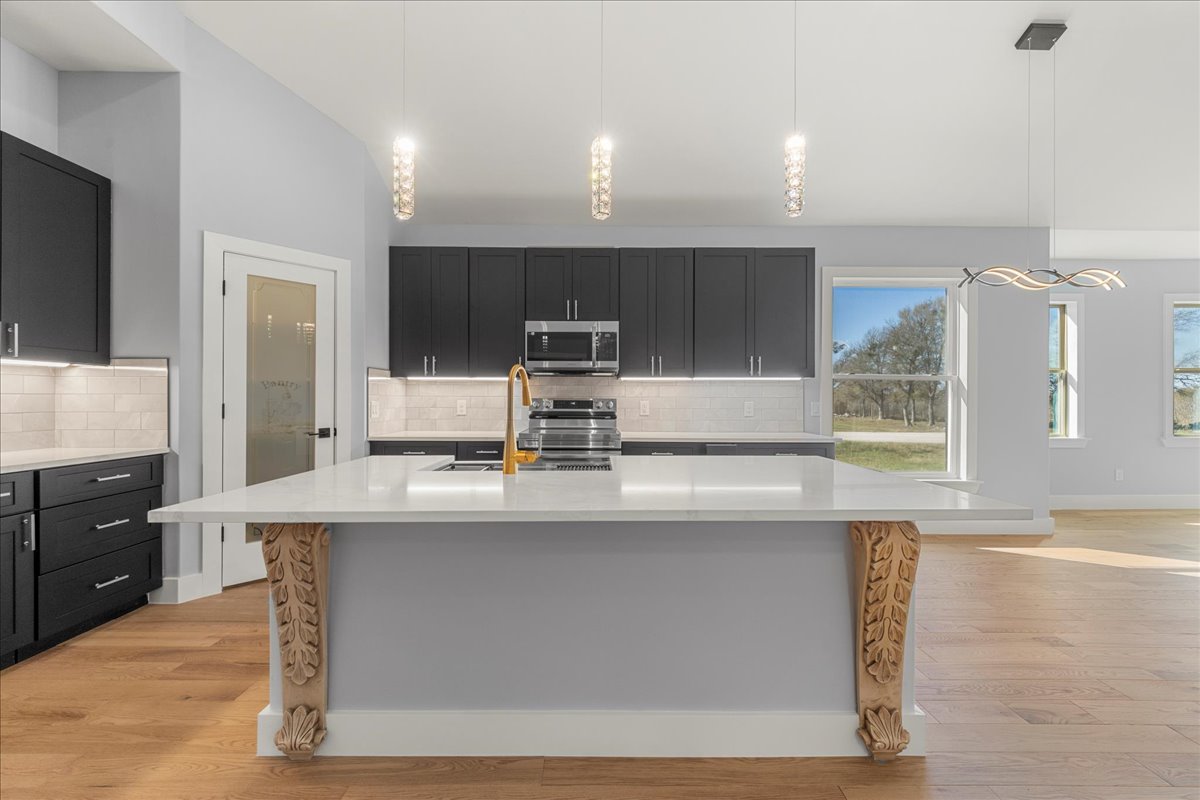217 Gato Road Cedar Creek, TX 78612 - Photo 9 of 40 a kitchen with kitchen island granite countertop a sink counter top space and cabinets