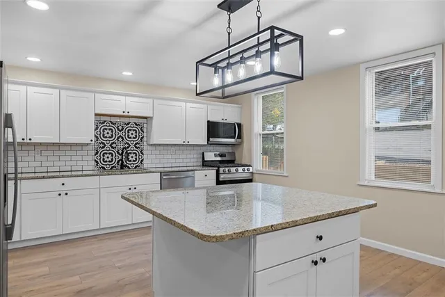 a kitchen with stainless steel appliances granite countertop a sink a stove and center island