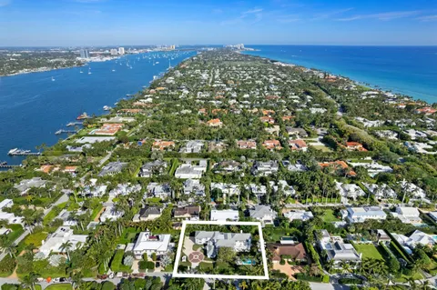 a view of a white house with a yard and potted plants