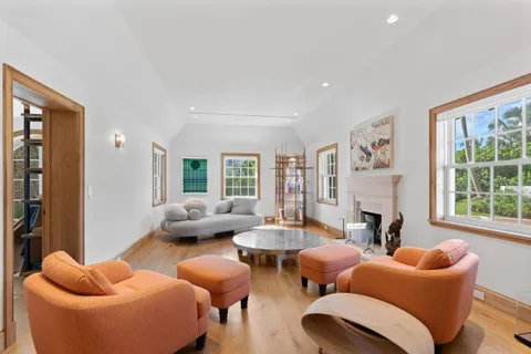 a living room with furniture fireplace and a large window