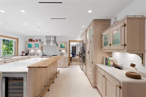 a kitchen with kitchen island granite countertop a stove and a sink