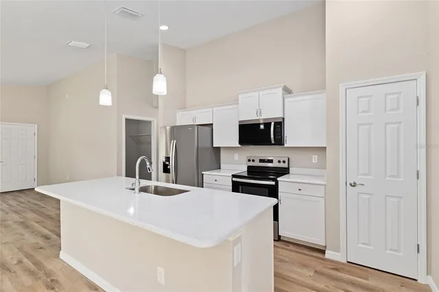 a kitchen with stainless steel appliances kitchen island sink refrigerator and microwave