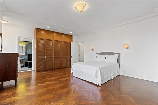 a bedroom with a bed and a refrigerator