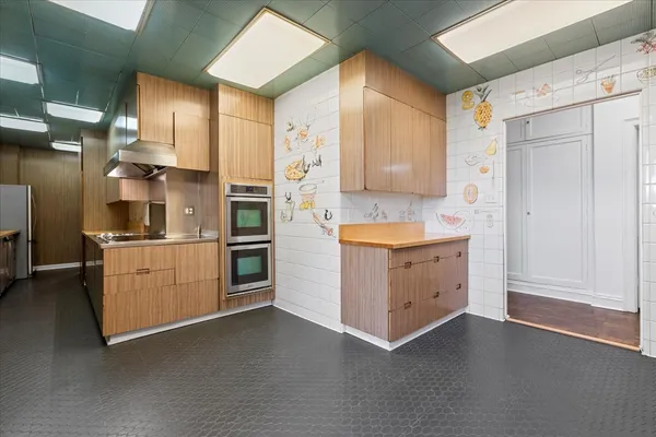 a kitchen with a refrigerator stove and white cabinets