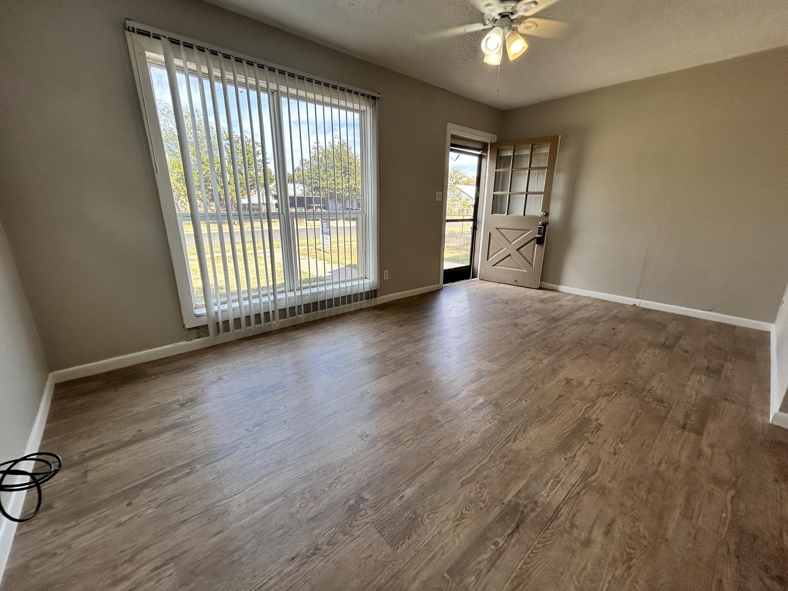 1313 25th Street Lubbock, TX 79411 - Photo 2 of 9 a view of an empty room with a window and wooden floor