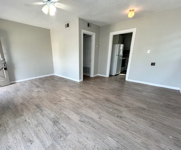 a view of an empty room with wooden floor
