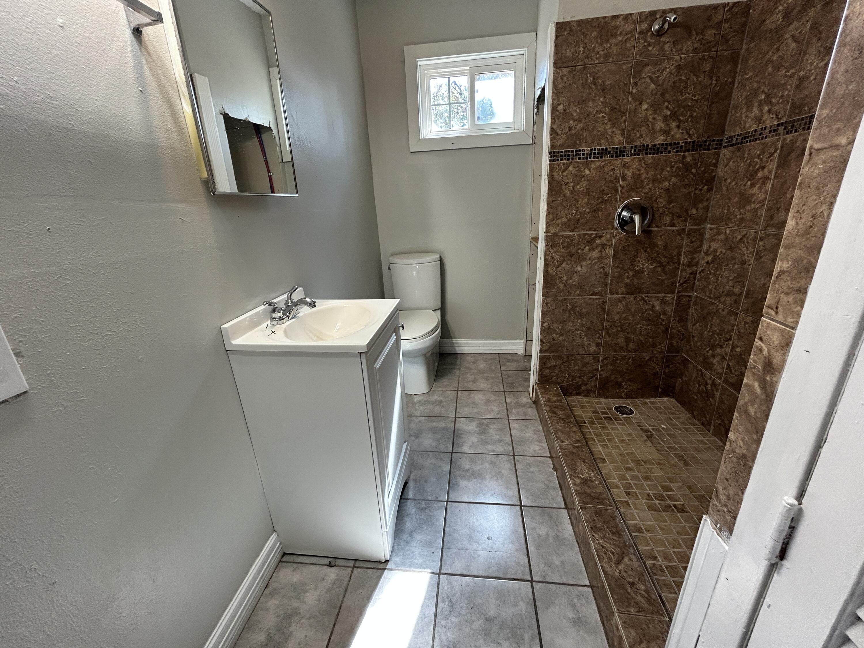 1313 25th Street Lubbock, TX 79411 - Photo 6 of 9 a bathroom with a sink a toilet and shower