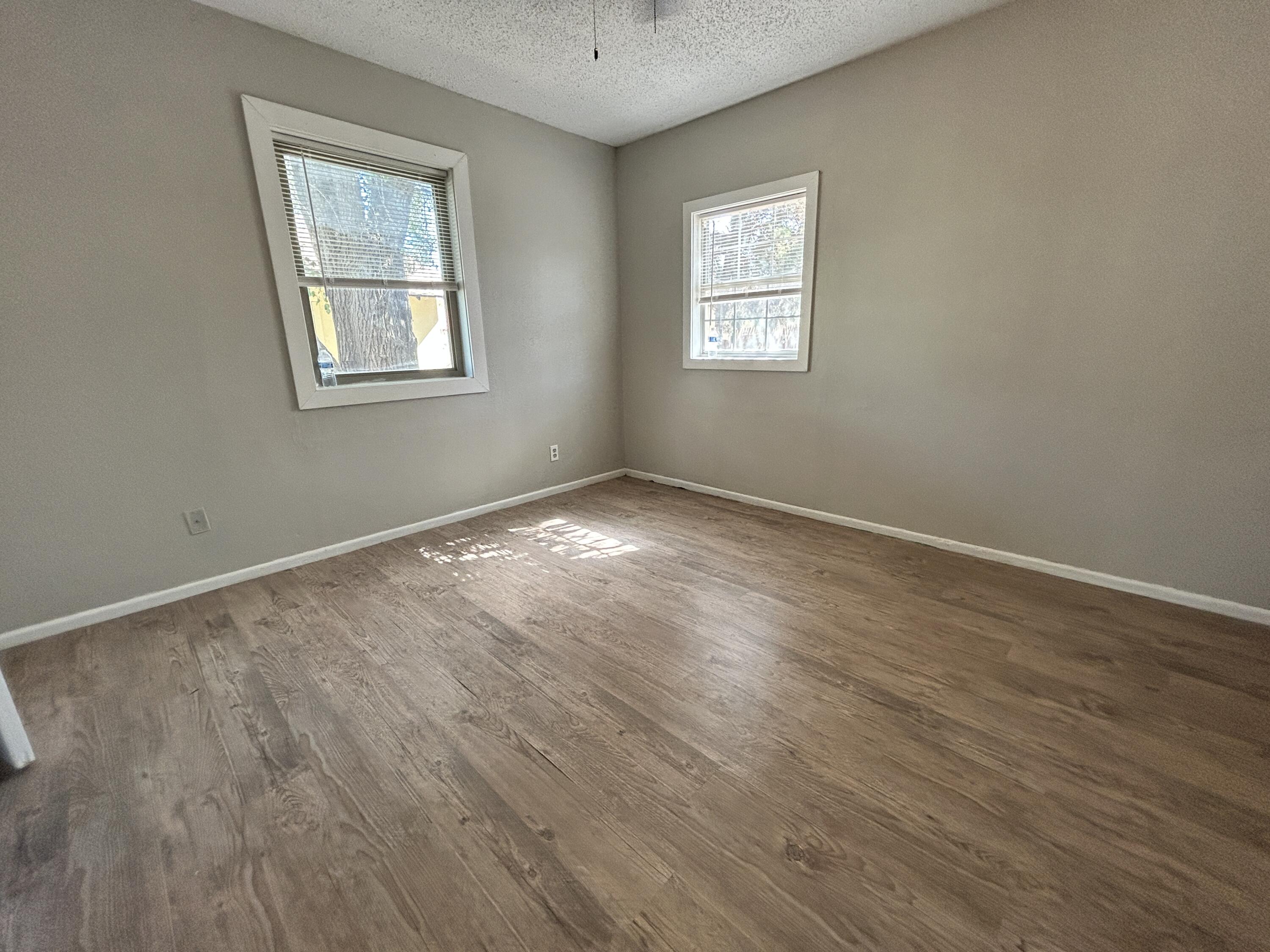 1313 25th Street Lubbock, TX 79411 - Photo 7 of 9 a view of an empty room with wooden floor and a window
