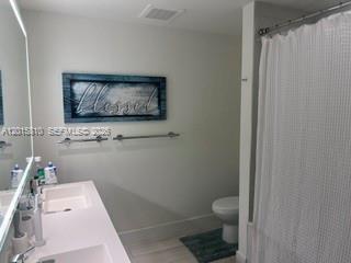 2000 Metropica Way, Unit 1902 Sunrise, FL 33323 - Photo 7 of 7 a bathroom with a toilet and a shower curtain