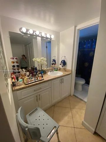 a en suite bathroom with a sink mirror and toilet