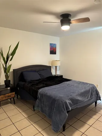 a bedroom with a bed and a potted plant