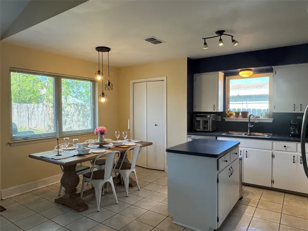 a kitchen with a table chairs sink and cabinets