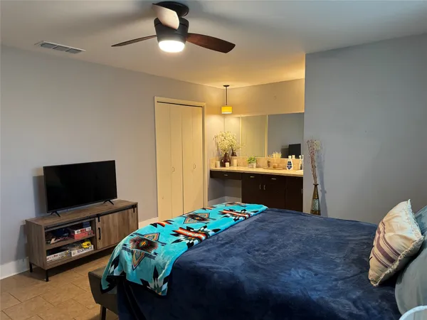 a bedroom with a bed and a flat screen tv