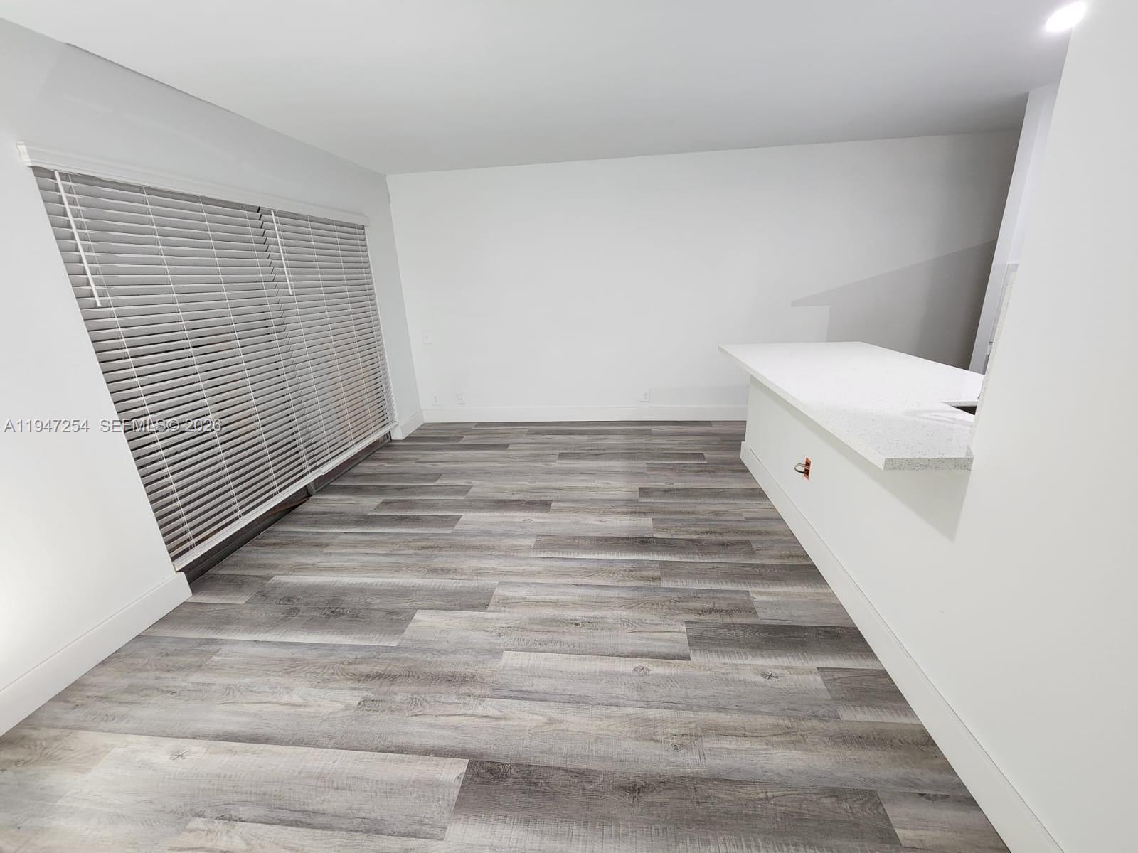 4545 Treehouse Lane, Unit H Tamarac, FL 33319 - Photo 11 of 18 a view of a hallway with wooden floor and staircase