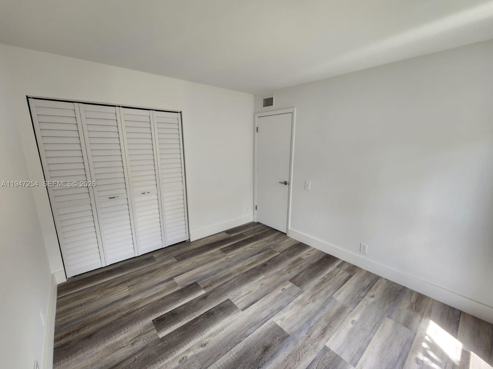 4545 Treehouse Lane, Unit H Tamarac, FL 33319 - Photo 15 of 18 a view of a room with wooden floor