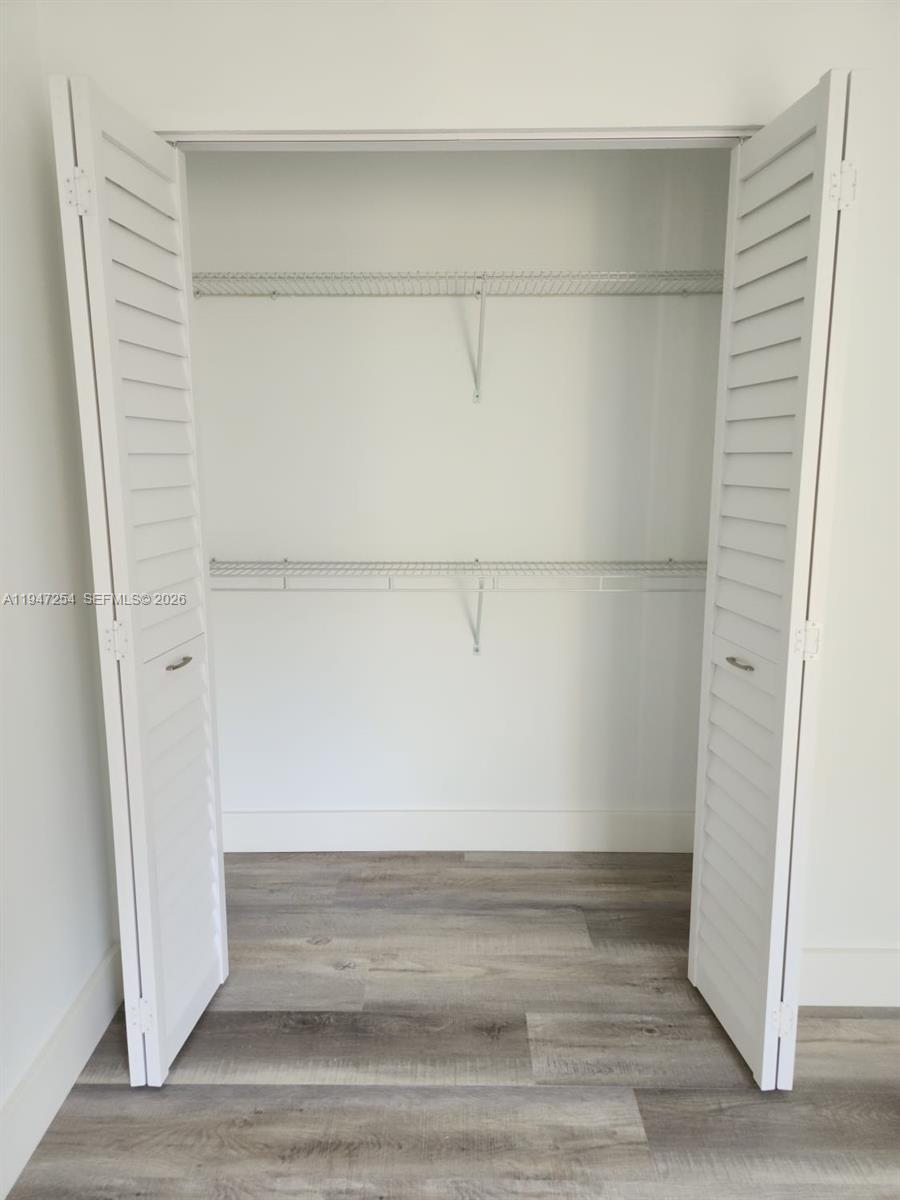 4545 Treehouse Lane, Unit H Tamarac, FL 33319 - Photo 17 of 18 a view of walk in closet with empty racks