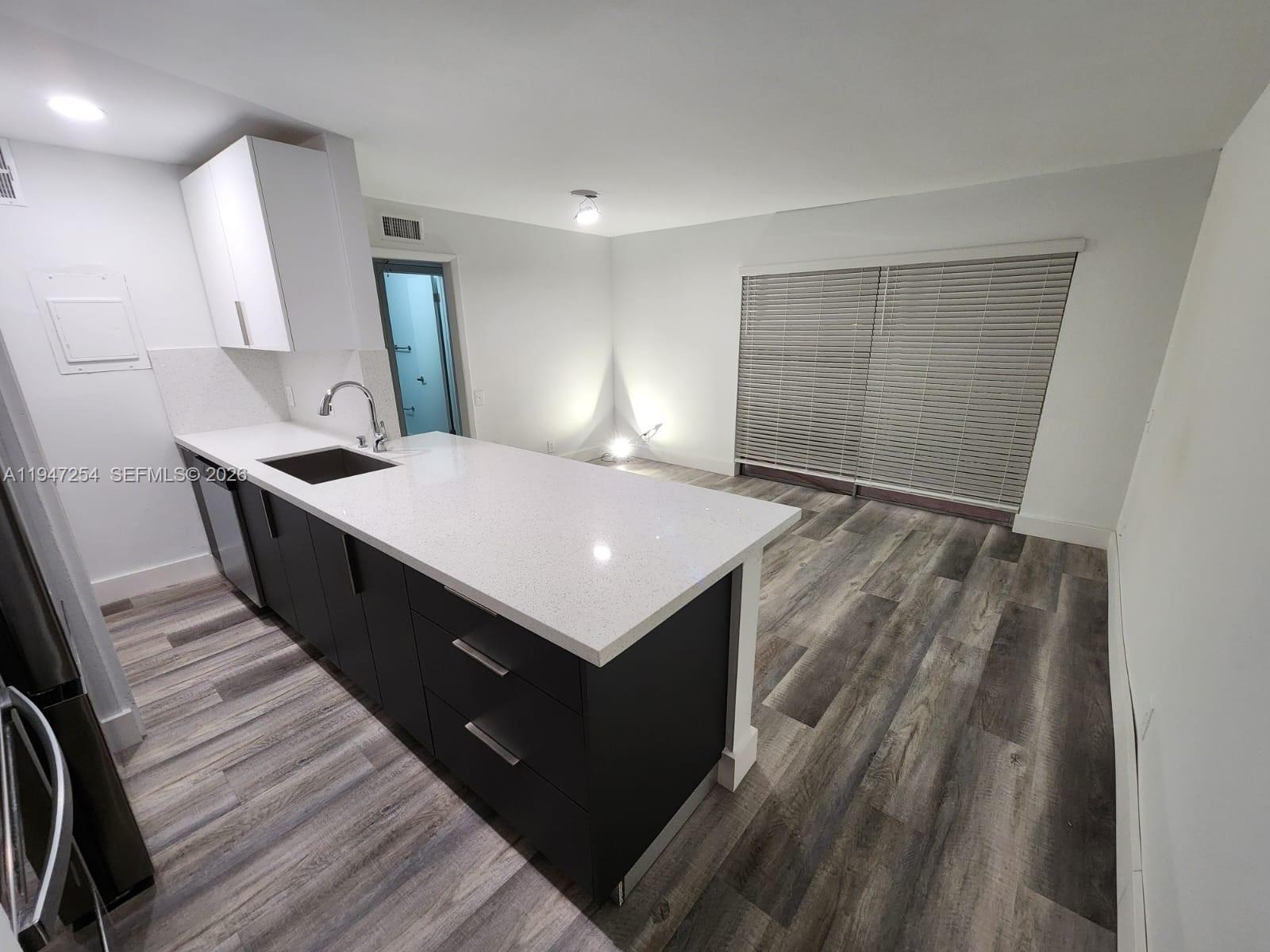 4545 Treehouse Lane, Unit H Tamarac, FL 33319 - Photo 3 of 18 a kitchen with a sink and a refrigerator