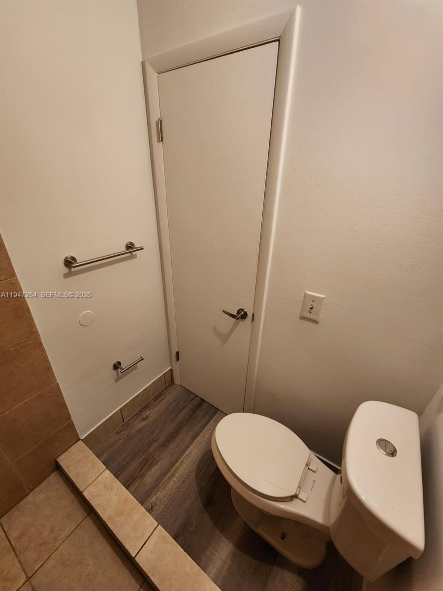 4545 Treehouse Lane, Unit H Tamarac, FL 33319 - Photo 9 of 18 a bathroom with a toilet and a shower