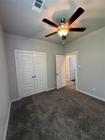 an empty room with closet and fan