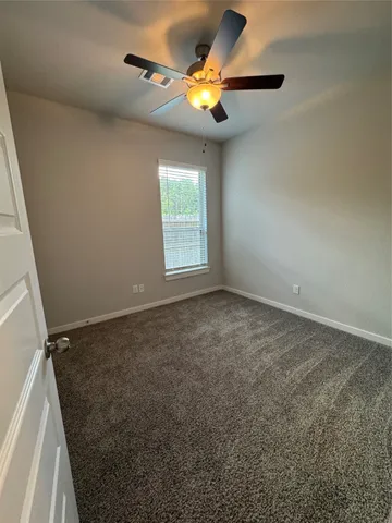 an empty room with a window and a fan