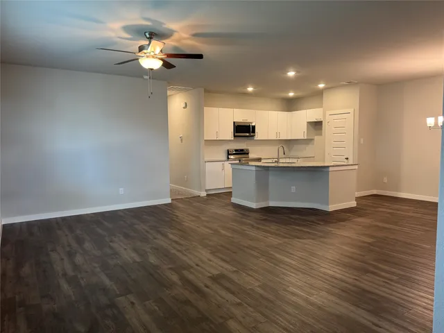 a view of kitchen with granite countertop cabinets and refrigerator
