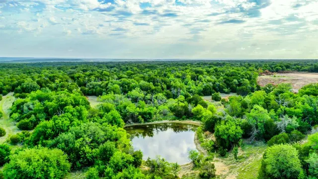an aerial view of a house with a yard and lake view