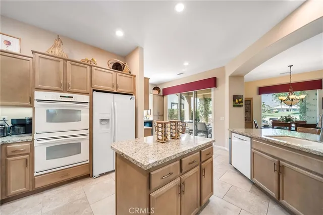 a kitchen with granite countertop a refrigerator and stove