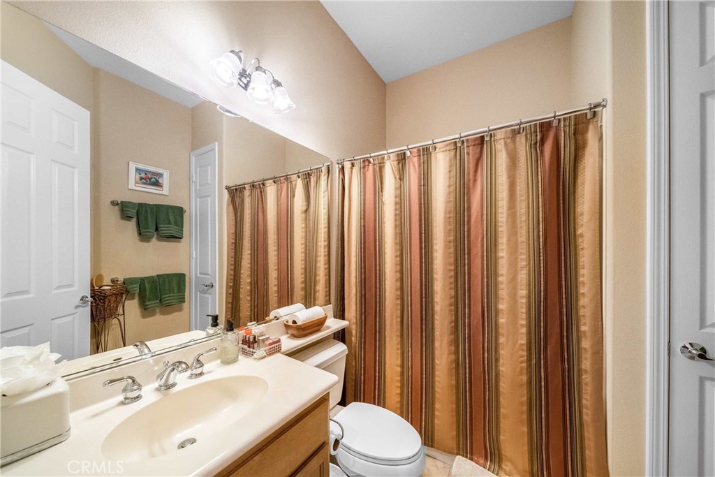 81955 Golden Star Way La Quinta, CA 92253 - Photo 27 of 54 a bathroom with a sink a toilet and shower curtain
