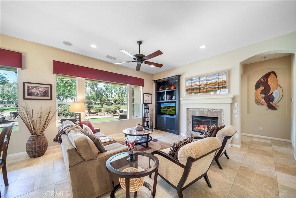 81955 Golden Star Way La Quinta, CA 92253 - Photo 3 of 54 a living room with furniture a fireplace and a floor to ceiling window