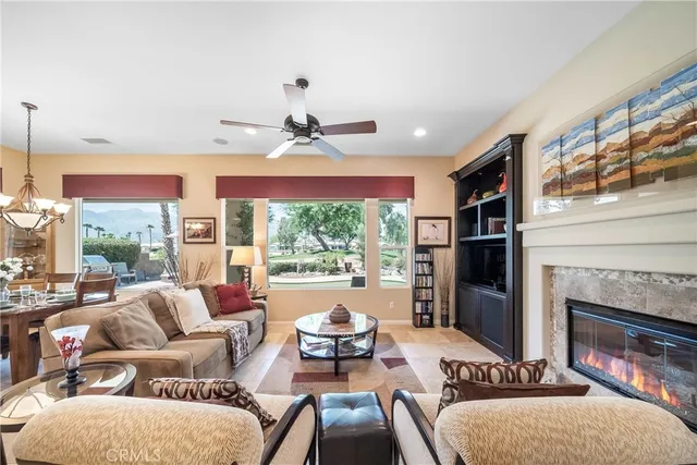 a living room with furniture a fireplace and a large window