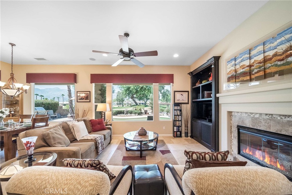 81955 Golden Star Way La Quinta, CA 92253 - Photo 4 of 54 a living room with furniture a fireplace and a large window