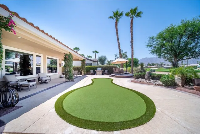 a view of a patio with couches table and chairs potted plants and palm tree