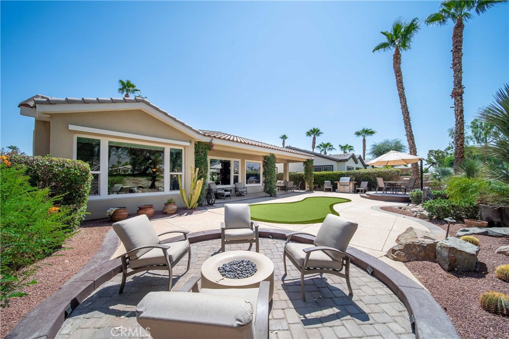 81955 Golden Star Way La Quinta, CA 92253 - Photo 46 of 54 a view of a patio with couches table and chairs potted plants and palm tree