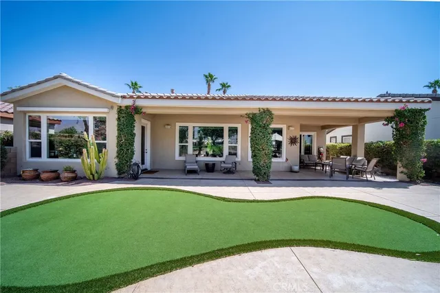a view of a patio with couches potted plants and a big yard