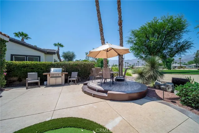 a view of a swimming pool with a table and chairs under an umbrella
